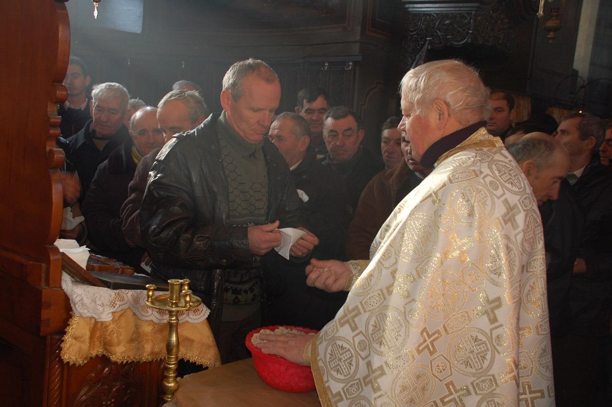 Preotul paroh împărțind anafură